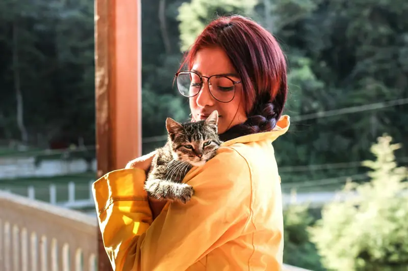 Young woman holding her rescue kitten